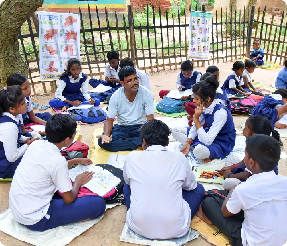 Mentor conducting a group counselling session with students sitting together outdoors, discussing studies and career guidance